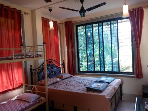 BhogweGovindaashram的一间卧室设有两张双层床和一扇窗户。
