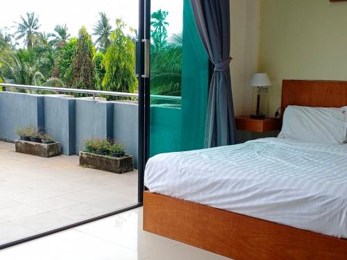 Ban Khlong HaengSj House Hotel Aonang的一间卧室设有一张床,享有阳台的景色