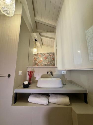 蒙特法尔科Appartamenti L'Ambulante的浴室配有盥洗盆、镜子和毛巾