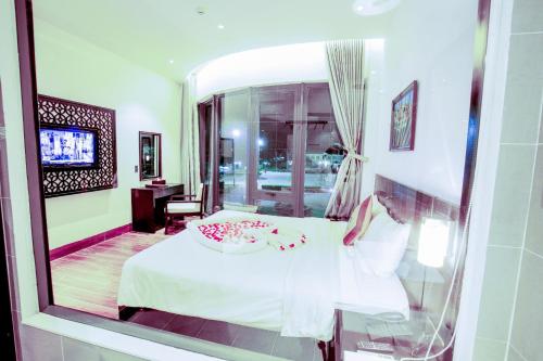 惹岛Ly Son Pearl Island Hotel & Resort的卧室的倒影,卧室的窗户上配有一张床