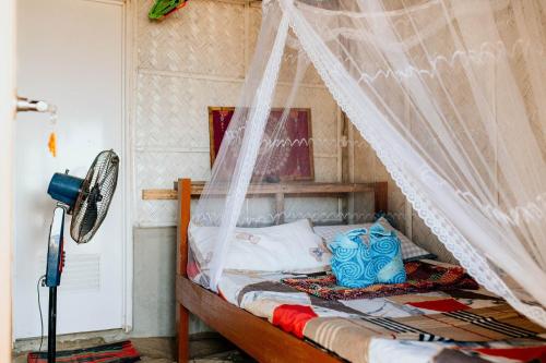 爱妮岛Bucana Beach Camp的一间卧室配有一张带蚊帐的床