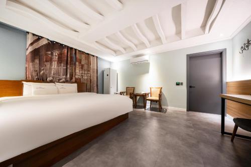 木浦市Hotel New Evergreen的一间卧室配有一张大床和一张书桌