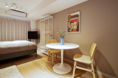 东京Section L Residence Ginza的配有一张床和一张桌子及椅子的房间