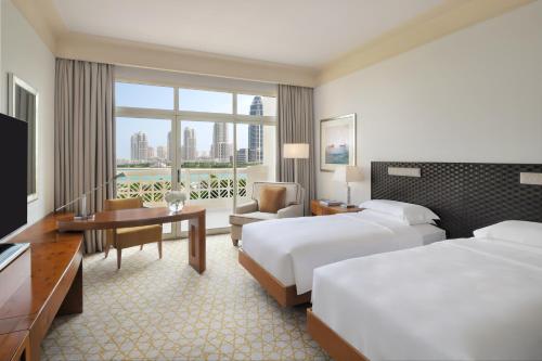 多哈多哈君悦别墅酒店的酒店客房配有两张床和一张书桌