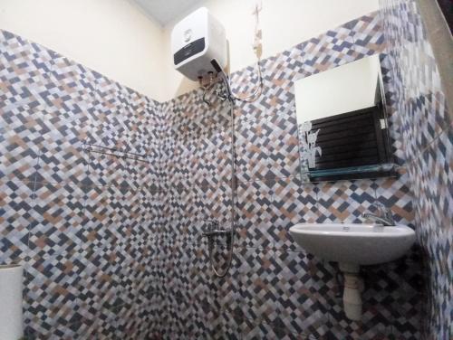 TelagaMaherza Syariah Homestay Gorontalo RedPartner的一间带卫生间、水槽和镜子的浴室