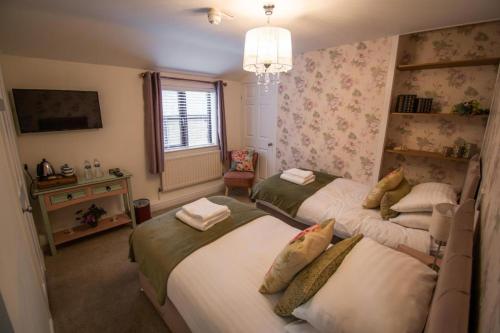 CottinghamThe Royal George的一间卧室设有两张床和窗户。