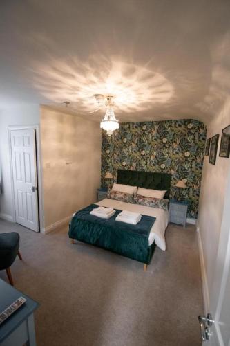 CottinghamThe Royal George的一间卧室配有一张带绿毯的大床