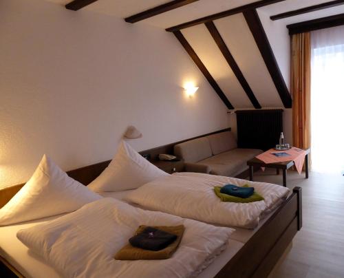 伦山前比绍夫斯海姆Pension Gasthof Zum Lamm的酒店客房,设有两张床和一张沙发