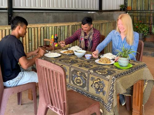 邦隆Backpacker Hostel and Jungle Trekking的一群坐在桌子旁吃食物的人