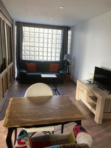 卢昂appartement terrasseLouhans centre的客厅配有沙发和桌子