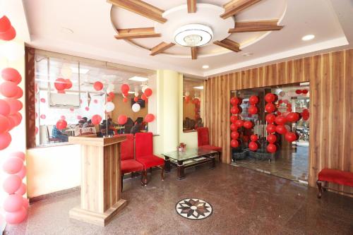 戈勒克布尔Hotel Centre Point的一间设有气球、红色椅子和吊灯的房间