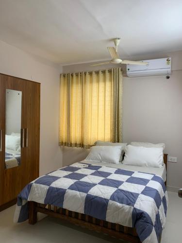 特里凡得琅Aami guest house 03 osko building的卧室配有蓝色和白色的床和窗户。