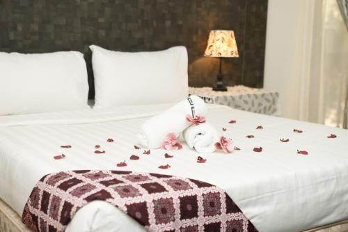 马六甲Putera Island Resort的上面有玫瑰的床,上面有种动物