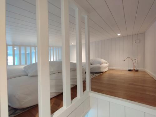 博尔斯塔Bålsta Studio Houses的卧室配有2张床、白色墙壁和木地板