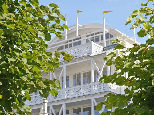 奥斯赛拜-塞林Villa "Johanna" Sellin - WG11 mit Kamin und großer Terrasse的带阳台和树木的白色建筑