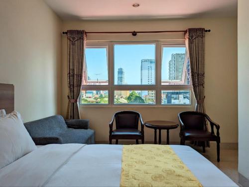 金边中青秋果酒店 True Go Hotel的一间卧室配有床、椅子和窗户