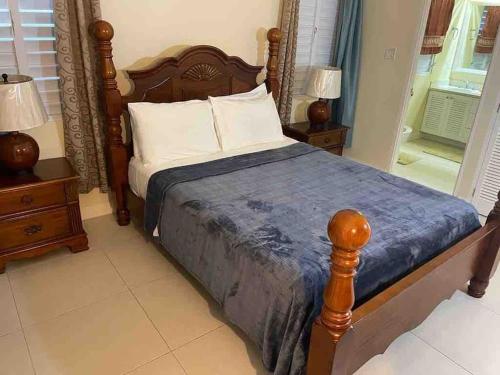 RichmondOasis @ Richmond Estate - Ocho Rios - St Ann的一间卧室配有一张木架床和2个床头柜。