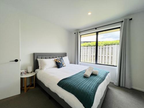 箭镇Leisure Holiday Home Lake Hayes Easte Queenstown的一间卧室设有一张床和一个大窗户