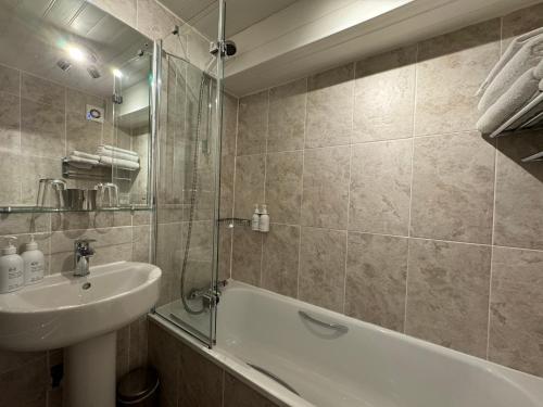 米德尔顿因蒂斯代尔Brunswick House的浴室配有盥洗盆、浴缸和盥洗盆