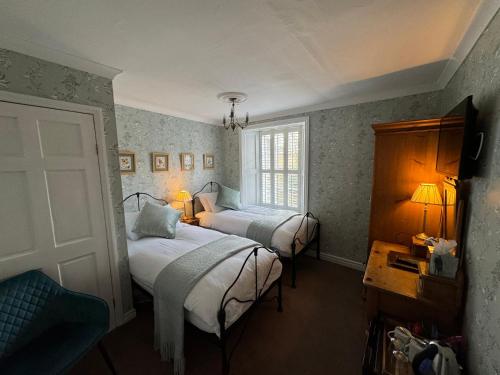 米德尔顿因蒂斯代尔Brunswick House的一间卧室设有两张床和窗户。