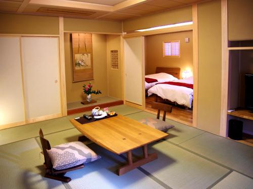 下吕市下吕温泉 悠久之华的客厅配有桌子和床。