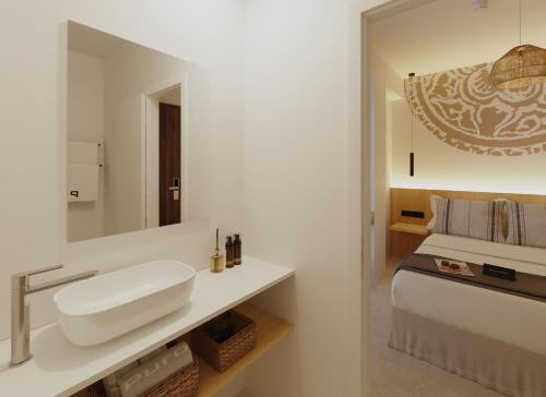 坎帕斯蒂利亚Sauló By Puro的白色的浴室设有水槽和一张床