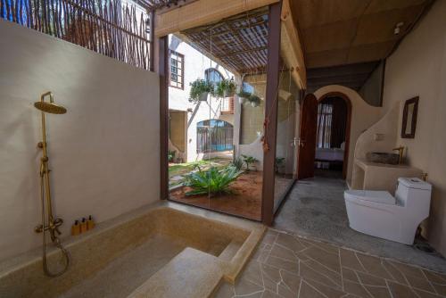 潘切Red Sands Pool Villa的带浴缸和卫生间的浴室。