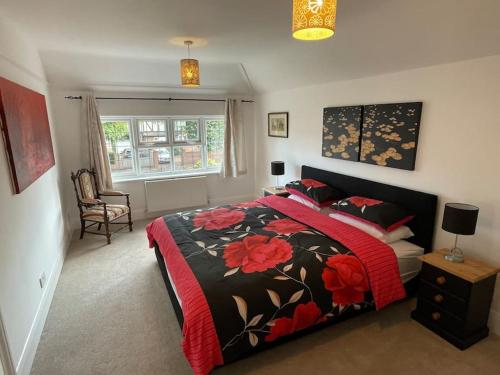东莫尔西Spacious 3 bedroom house in heart of Hampton Court的一间卧室配有一张带红色和黑色毯子的床