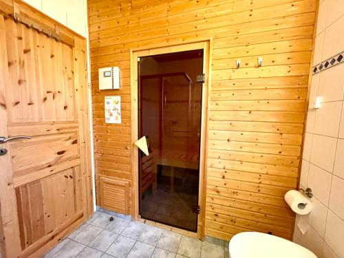 蒂门多夫Ferienhäuser Liethmann Haus 3 W 1的一间带卫生间和木墙的浴室
