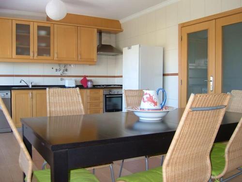 阿托吉亚达巴莱亚Fantastic 3 bedroom Villa - Peniche - Mer&Surf的厨房配有桌椅和冰箱。