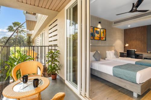 卡兰古特Quality Inn Ocean Palms Goa的一间卧室设有一张床和一个阳台