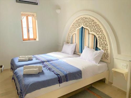 米多恩Hôtel Djerba Authentique - Au centre de Midoun的一间卧室配有两张带毛巾的床