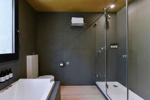 马萨纳NH Collection Andorra Palomé的带淋浴、卫生间和浴缸的浴室