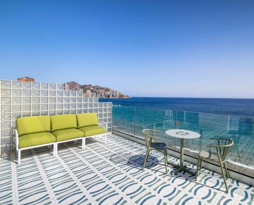 贝尼多姆Barceló Benidorm Beach - Adults Recommended的阳台设有一张沙发和一张桌子,享有海景。