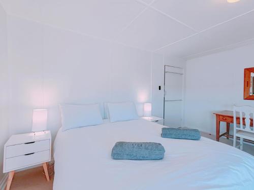 西蒙镇Timber's Ocean House的卧室配有白色的床和两个枕头