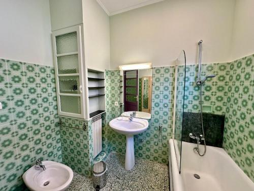 芒通APPARTEMENT MAISON, CENTRE VILLE, PROCHE PLAGE TOUT COMMERCE的浴室配有2个盥洗盆、淋浴和浴缸。