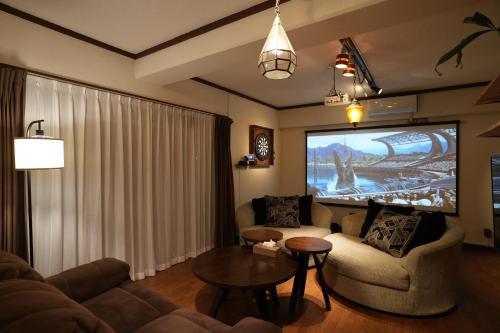 本部Cinema Resorts 3的客厅配有电视、沙发和桌子