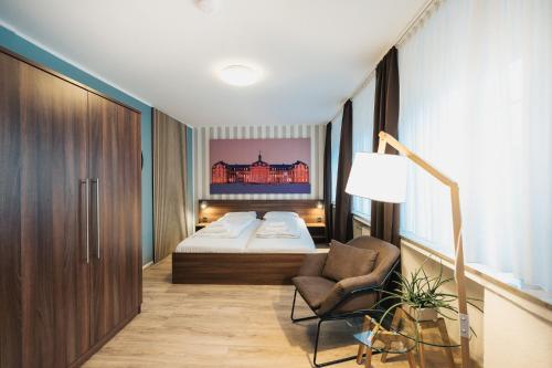 明斯特Hotel Busche am Dom的一间卧室,卧室内配有一张床和一把椅子