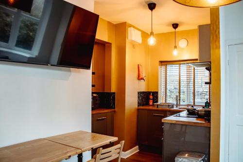 哈罗盖特Spacious Flat with Free Parking的厨房配有木桌和水槽。