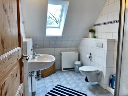 蒂门多夫Ferienhäuser Liethmann Haus 4 W2的一间带水槽和卫生间的浴室以及窗户。
