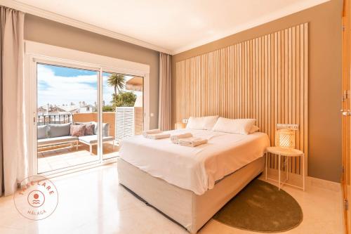 马贝拉Stylish Apartment Aloha Hill Club Marbella - TCM的一间带大床的卧室和一个阳台