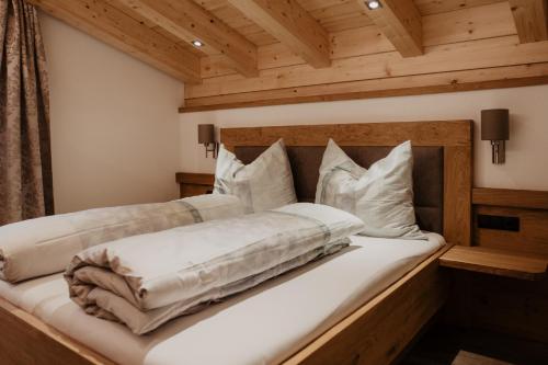 NavisBergler Hoamat - Mountain Hideaway的一间卧室配有带白色床单和枕头的床。