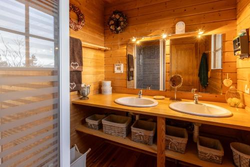 安格勒Le Chalet des Ours - Superbe chalet 4 étoiles的小木屋浴室设有2个水槽和1个镜子