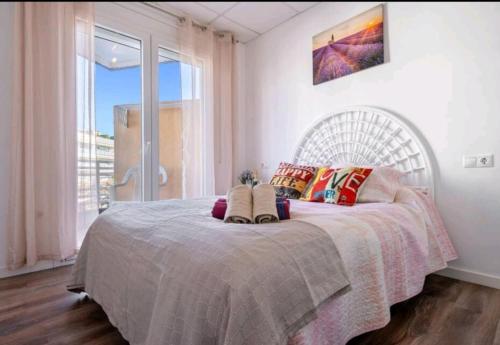 萨洛Apartamento Lauren Salou的一间卧室设有一张大床和大窗户