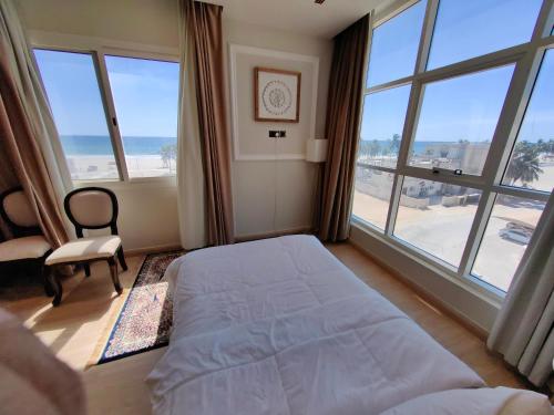 塞拉莱الشقة البحرية الدهاريز的一间卧室设有一张床和一个大窗户