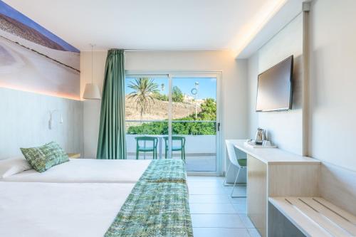 甘迪亚海滩FERGUS Cactus Garden的酒店客房设有一张床和一个阳台。