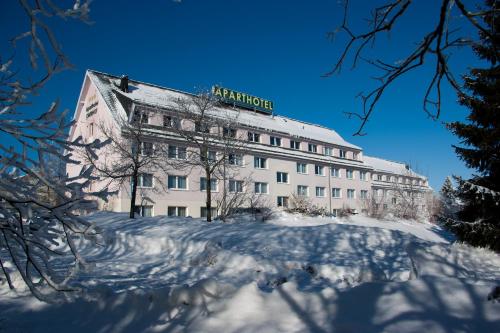 奥伯霍夫Aparthotel Oberhof的雪上有标志的建筑物