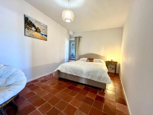 博尼法乔Joli T3 sur le port de Bonifacio avec vue mer的卧室配有1张床,铺有瓷砖地板。