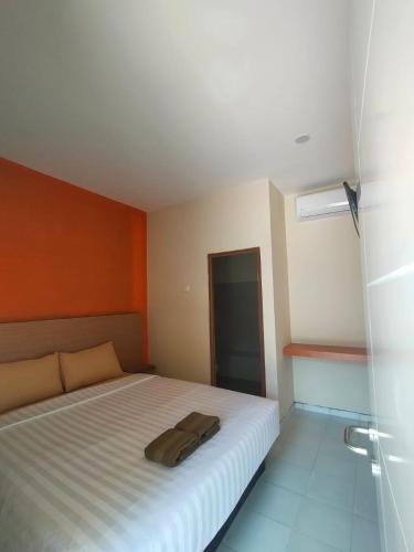 卡里蒙贾瓦Spazio Hotel的一间卧室配有一张白色的床和橙色的墙壁
