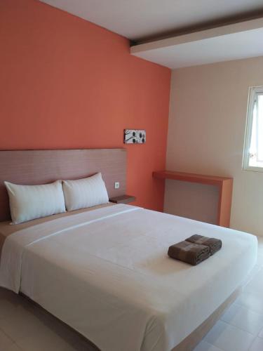 卡里蒙贾瓦Spazio Hotel的卧室配有白色大床和橙色墙壁